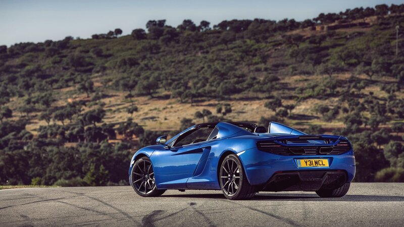 Blue McLaren convertible on a road