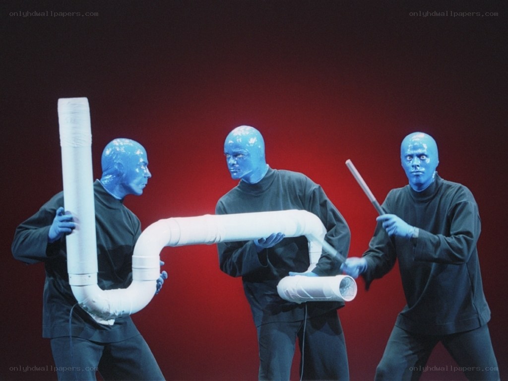 Blue men with pipes on stage