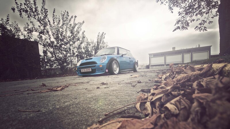 blue mini cooper on a leafy street