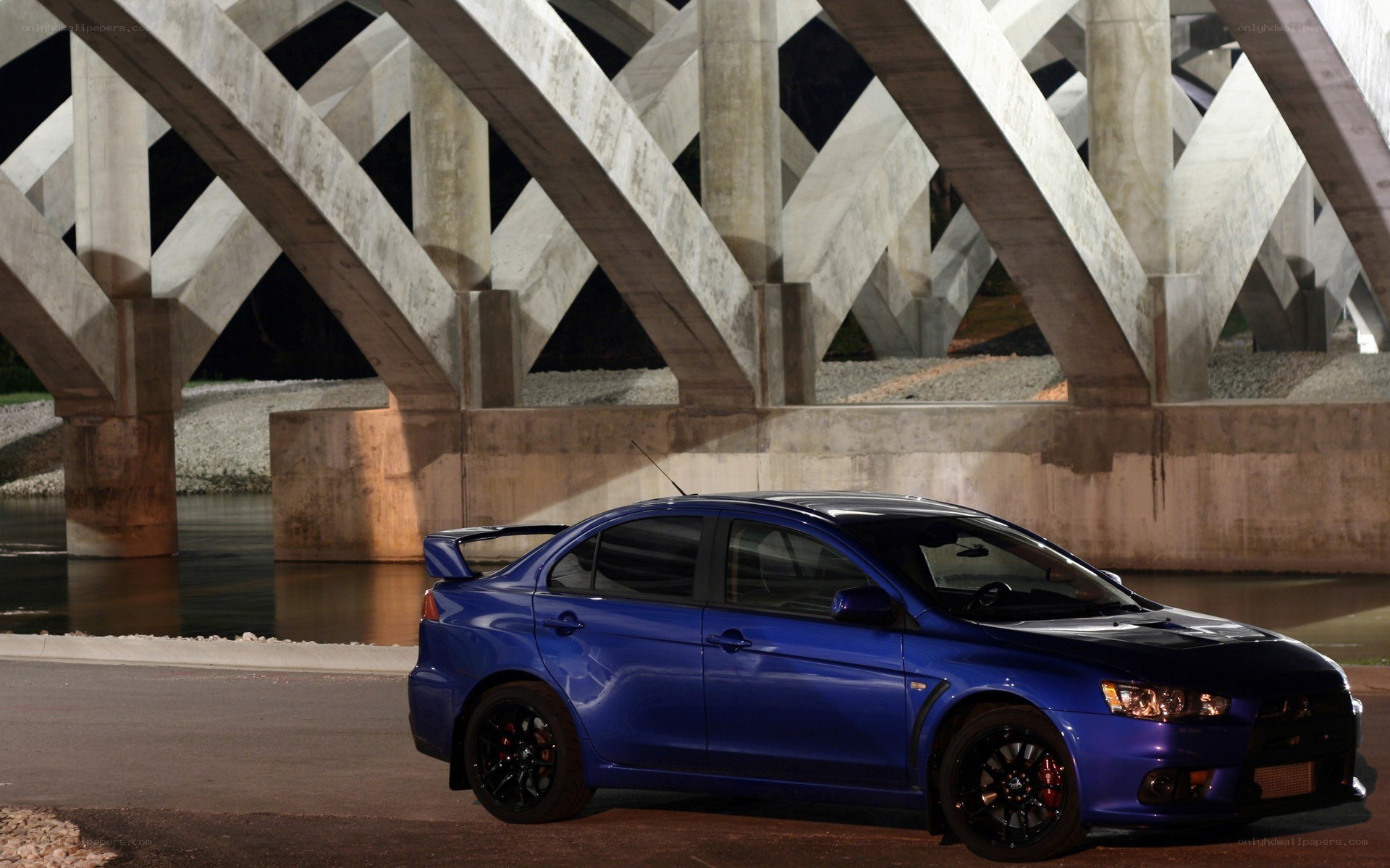 blue mitsubishi lancer evo under bridge