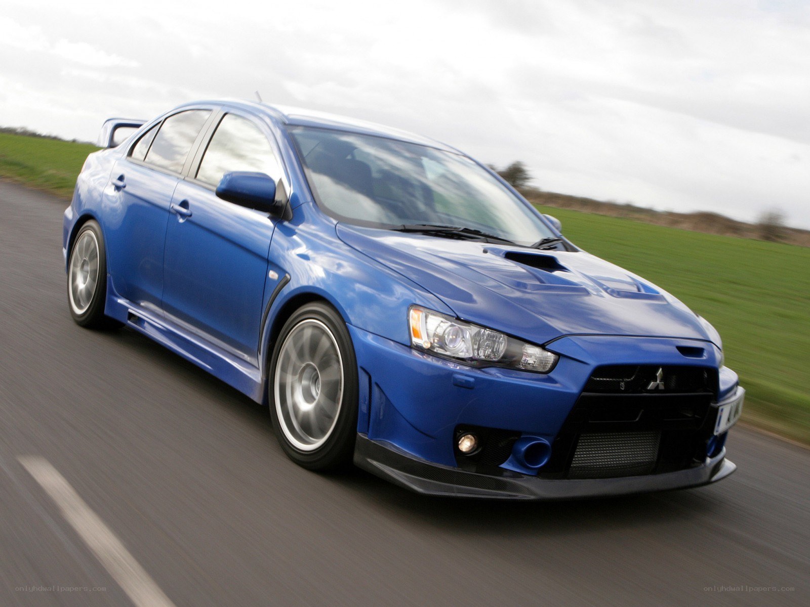 blue mitsubishi lancer evolution on road