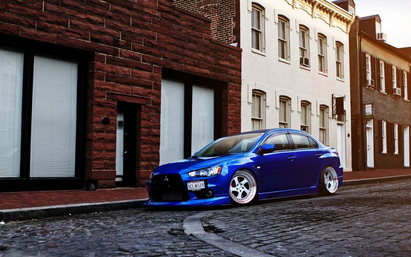 blue mitsubishi on cobblestone street