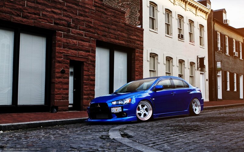 blue mitsubishi on cobblestone street