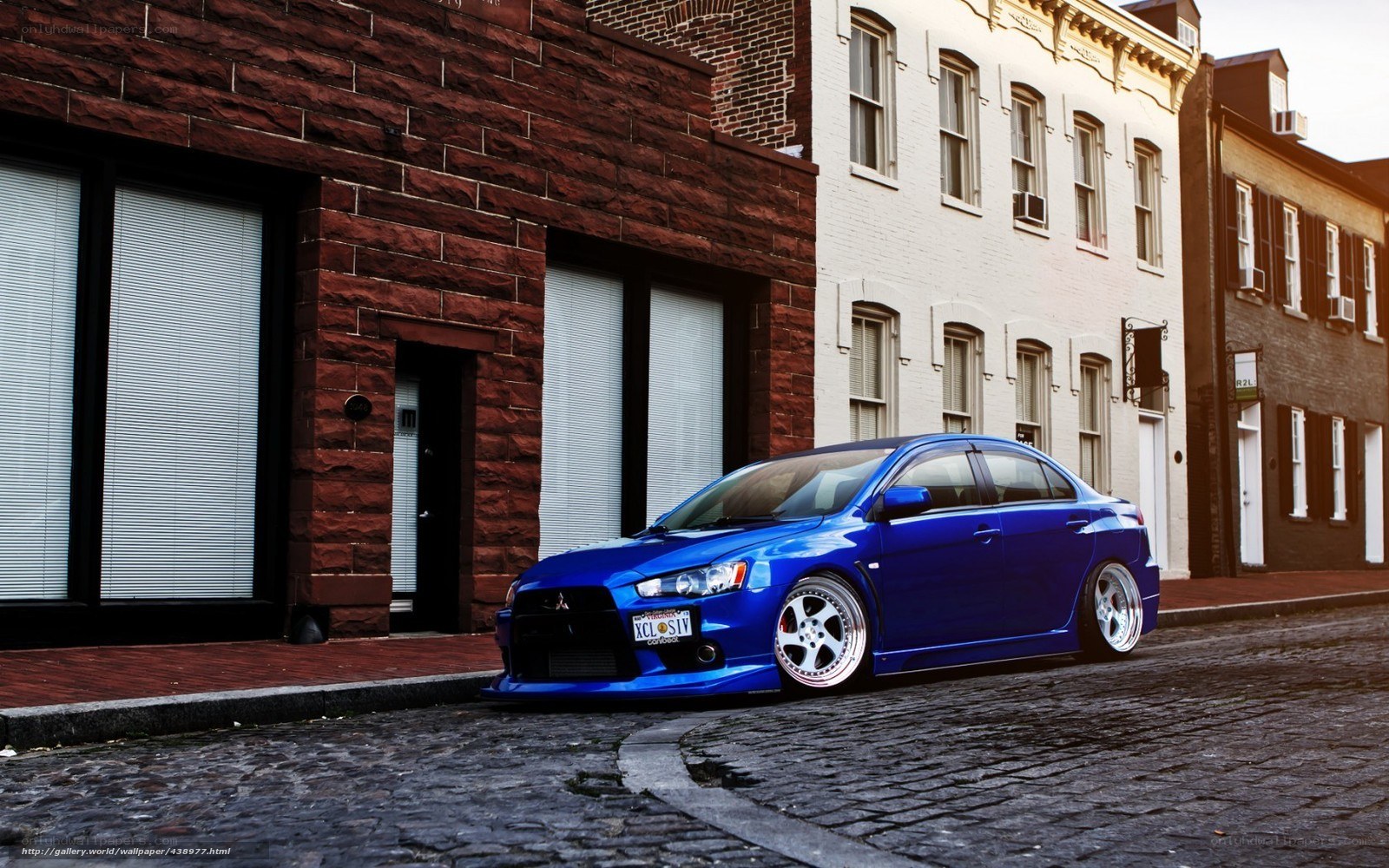 blue mitsubishi on cobblestone street
