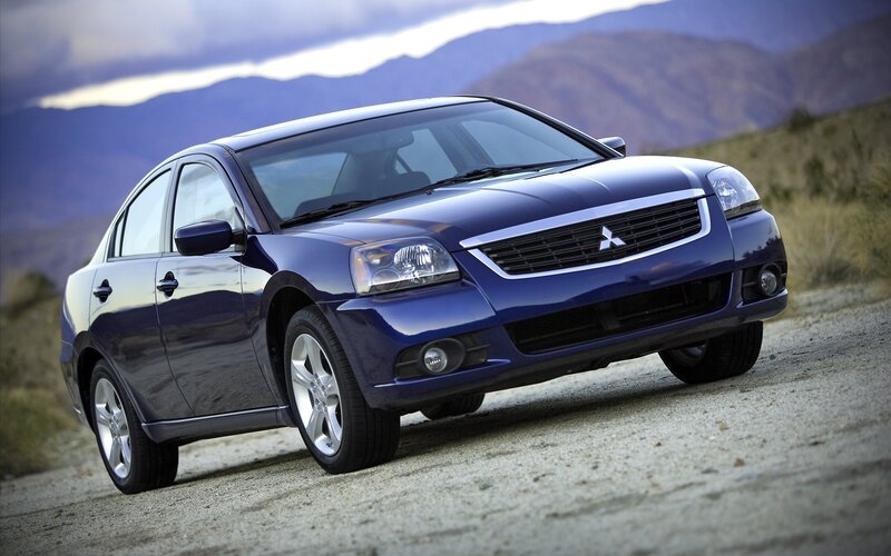 blue mitsubishi sedan on dirt road