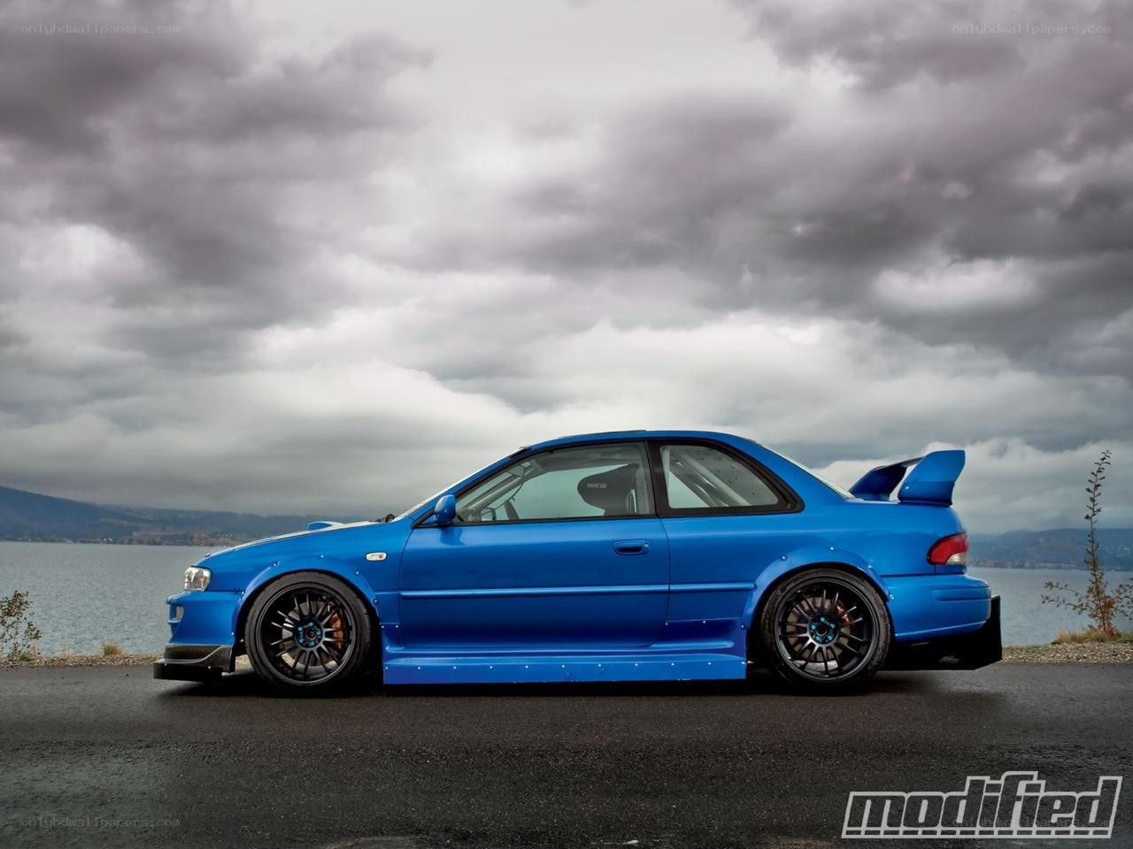blue modified car by water