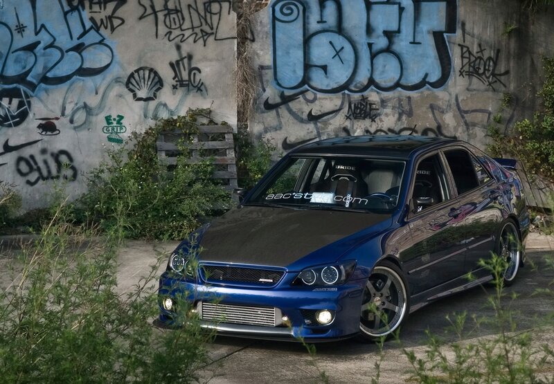 Blue modified car in graffiti alley