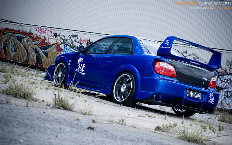 blue modified car with graffiti