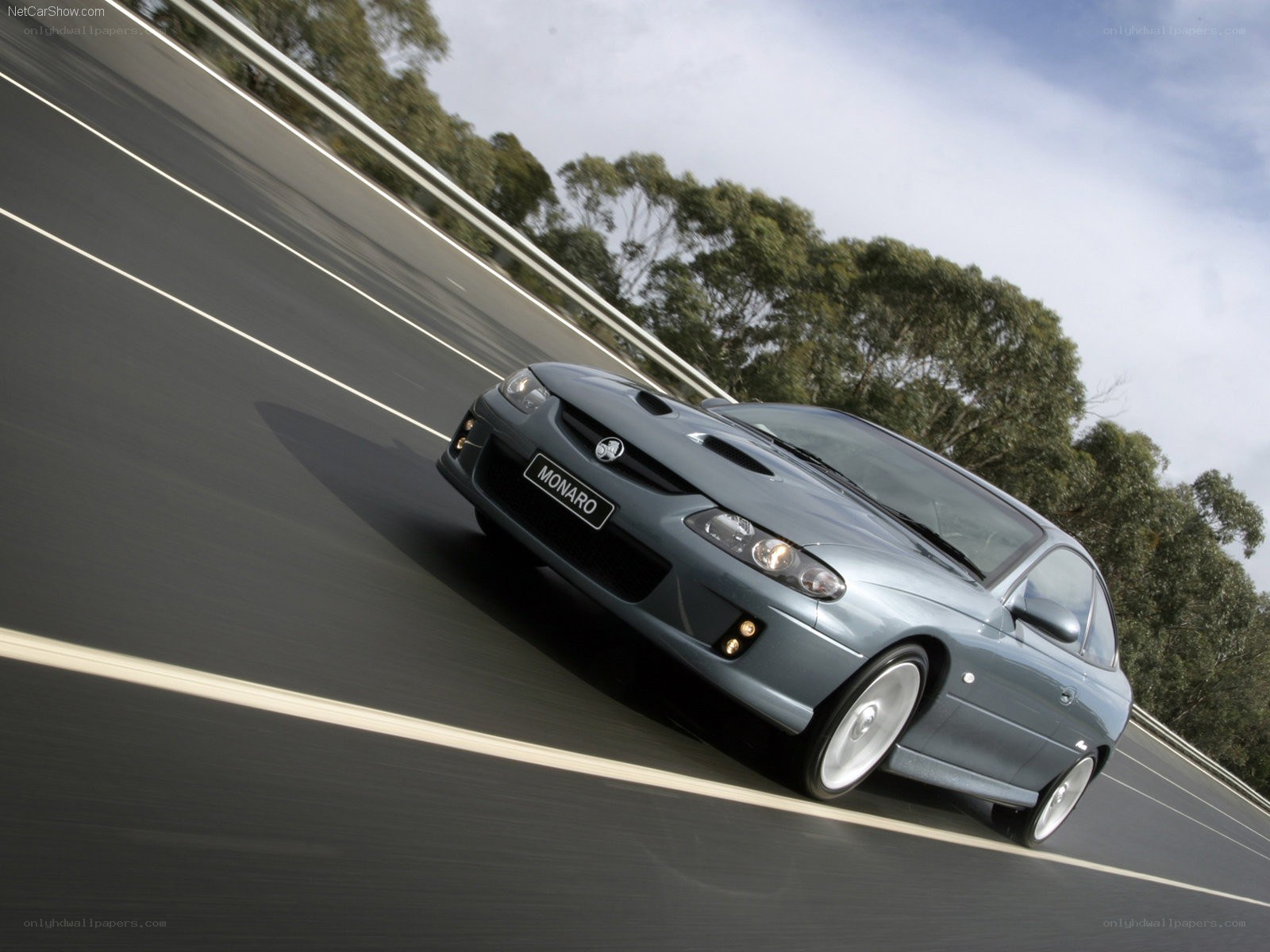 blue monaro on a winding road