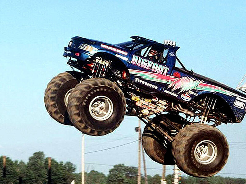 Blue monster truck in mid-air