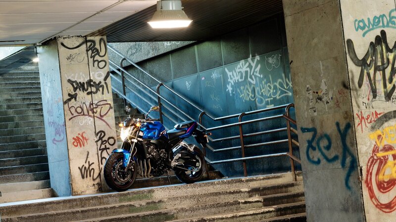 Blue motorcycle in graffiti alley
