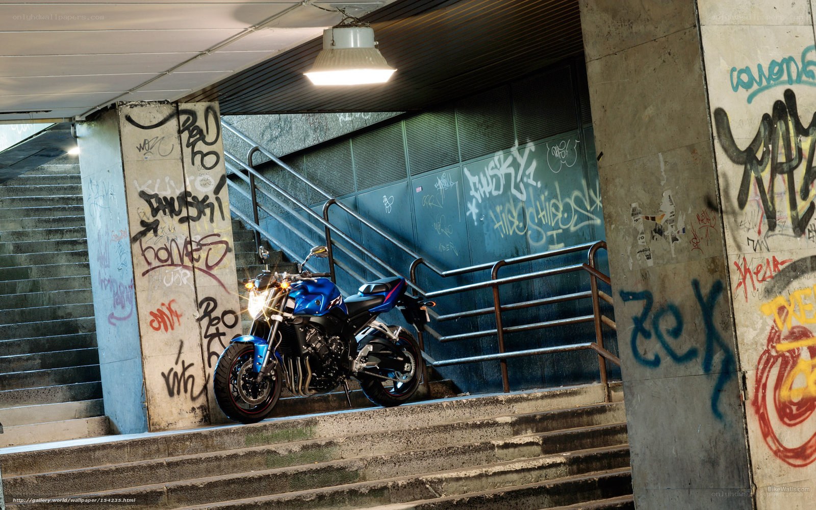 Blue motorcycle in graffiti tunnel