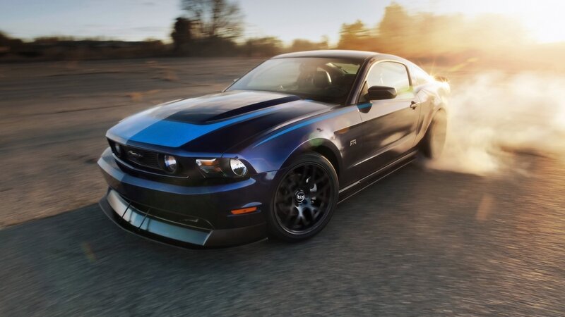 blue mustang drifting at sunset