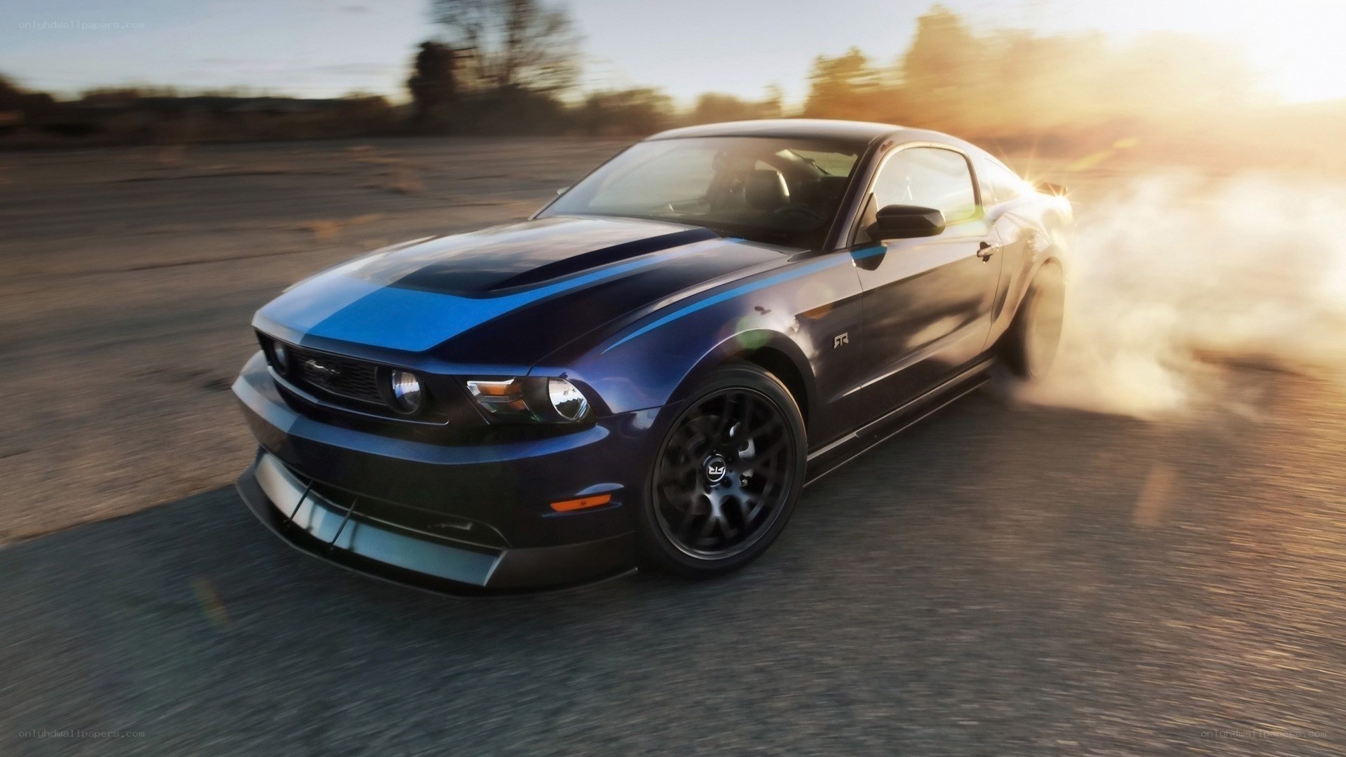 blue mustang drifting at sunset