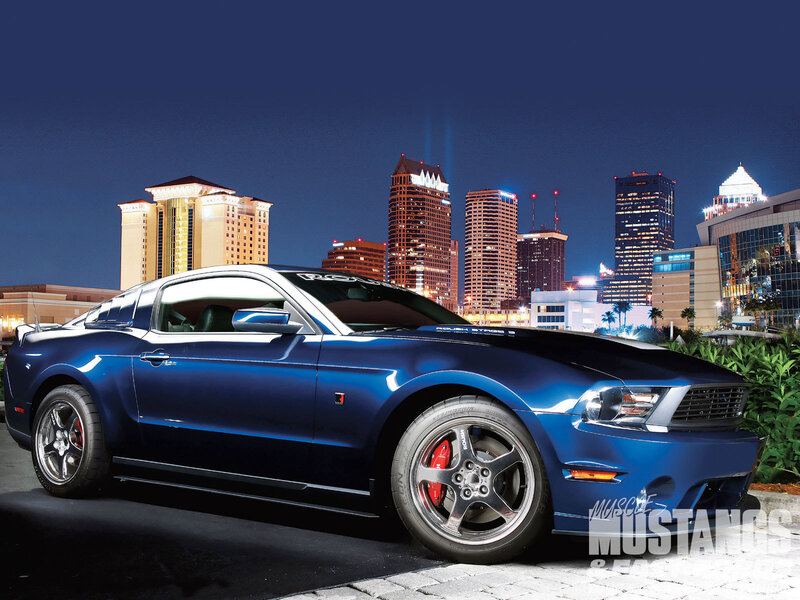 Blue Mustang in city at night