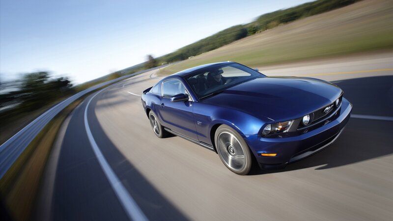 blue mustang on winding road