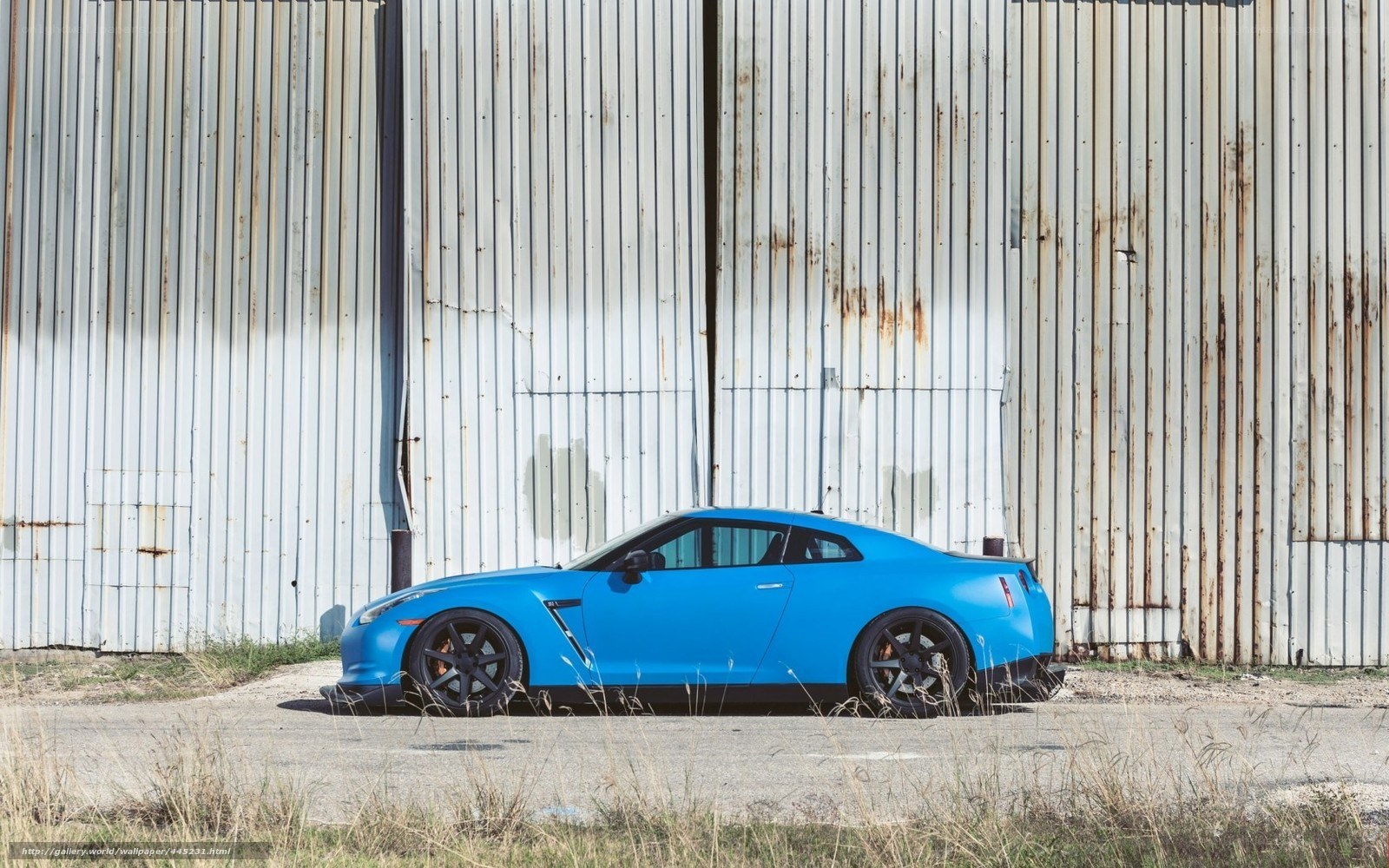 Blue Nissan GT-R by a warehouse