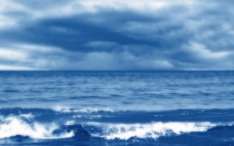 Blue ocean under cloudy sky