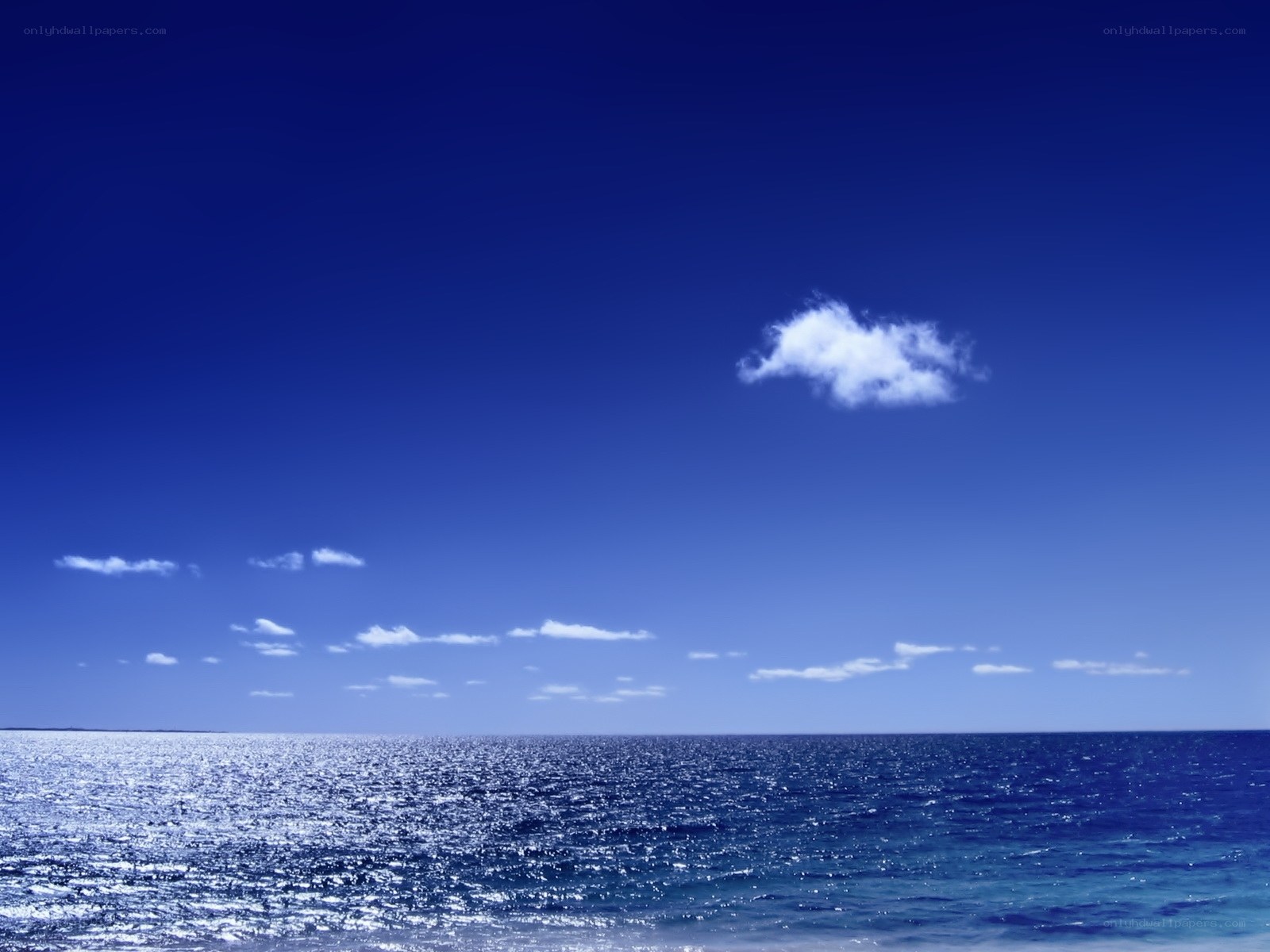 Blue ocean with single cloud