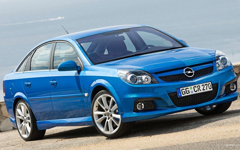 blue opel car on coastal road