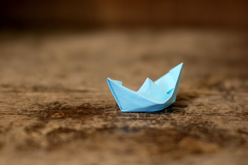 blue paper boat on wood