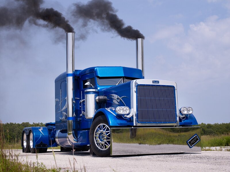 Blue Peterbilt truck with black smoke