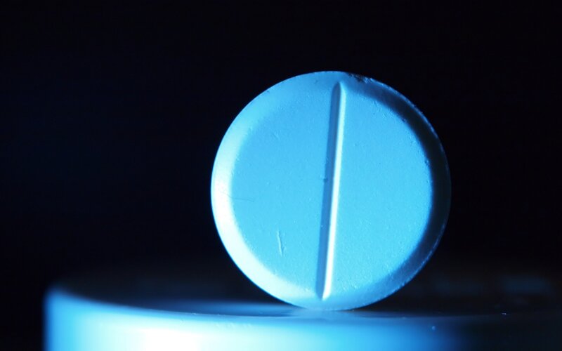 blue pill on dark surface