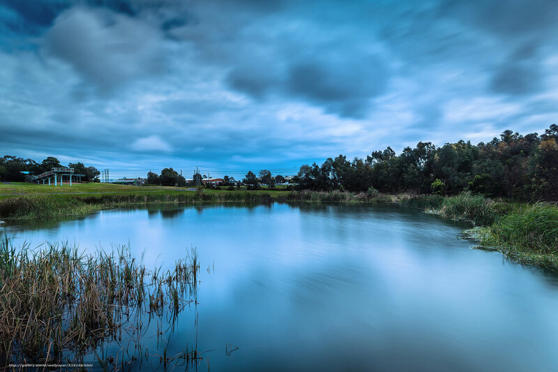 Blue pond under cloudy sky