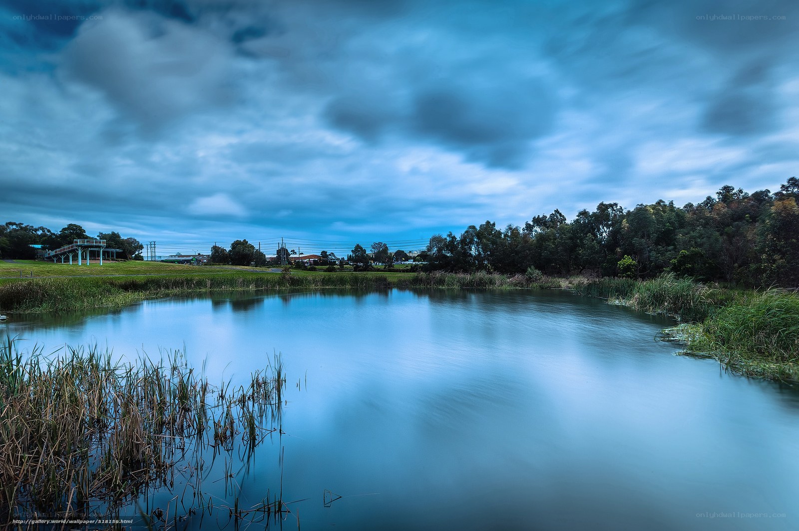 Blue pond under cloudy sky