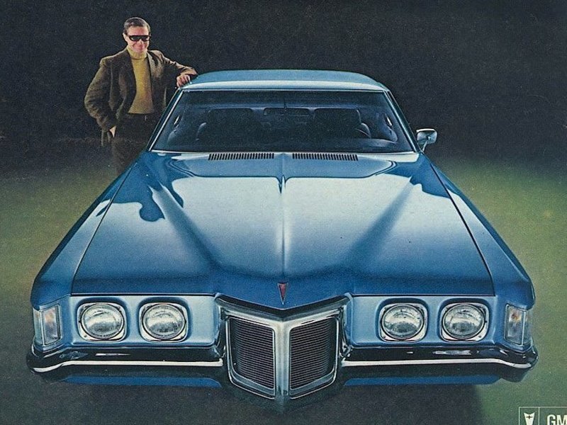 Blue Pontiac car with man