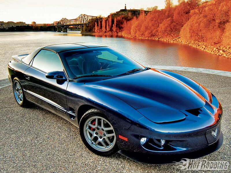 Blue Pontiac Firebird on riverbank