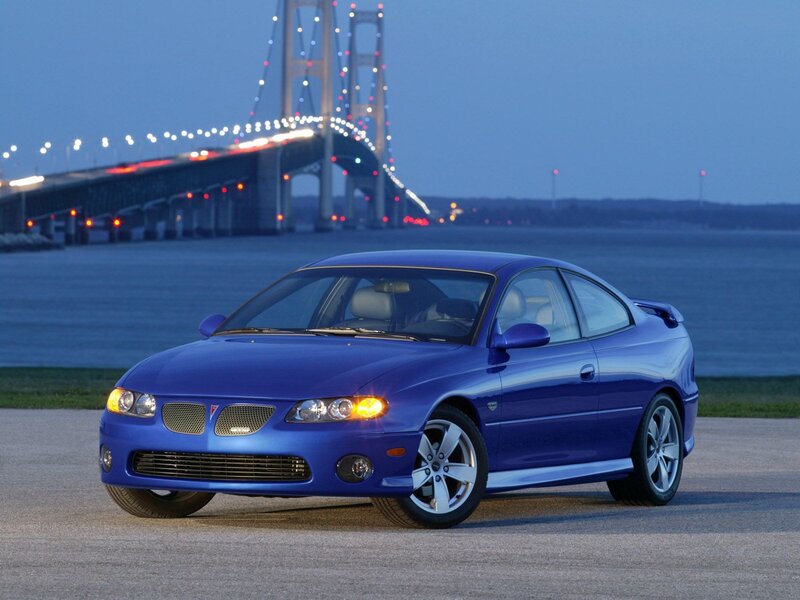 Blue Pontiac GTO by a bridge