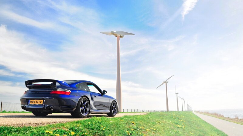 Blue Porsche 911 GT2 by wind turbines