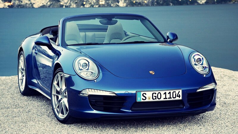 Blue Porsche convertible by the water