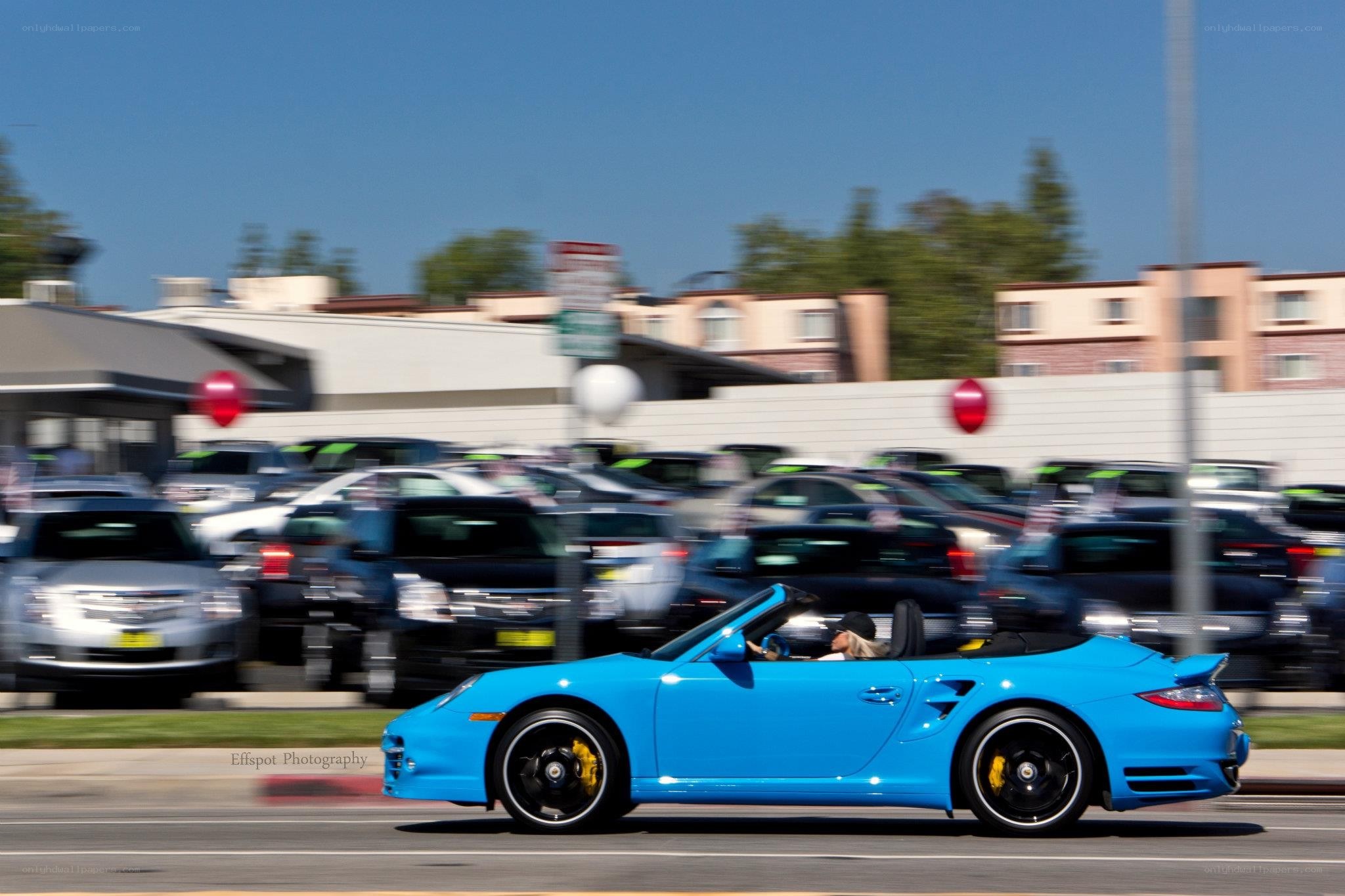Blue Porsche convertible in motion