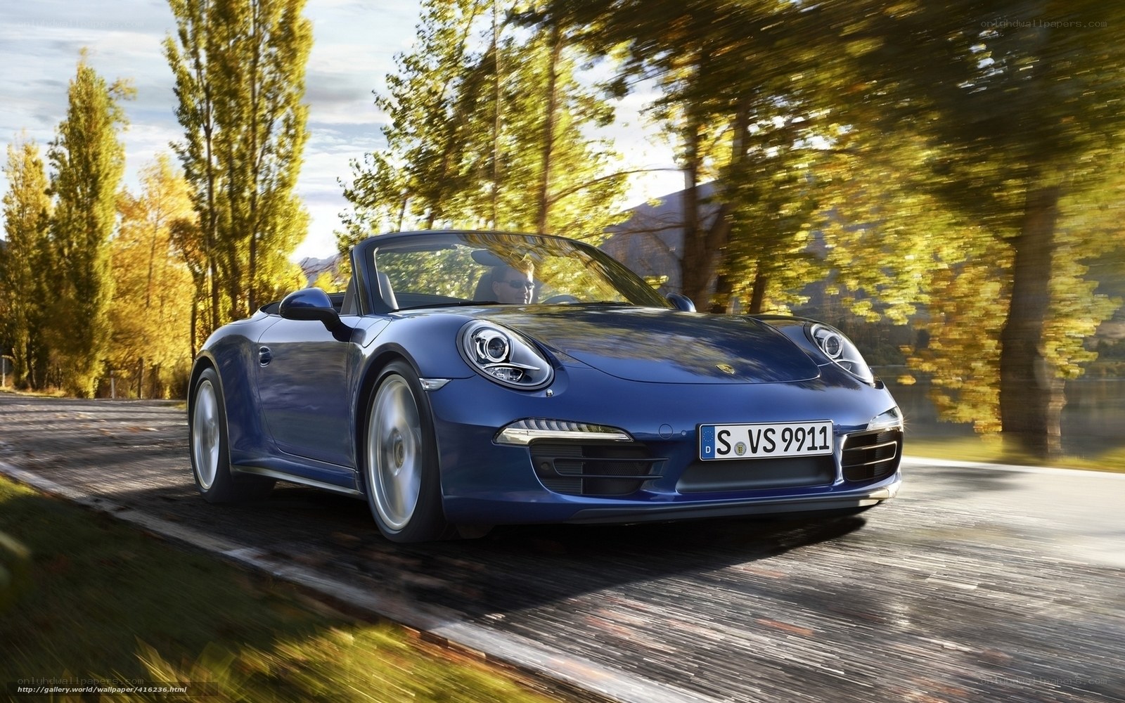 Blue Porsche convertible on a scenic road