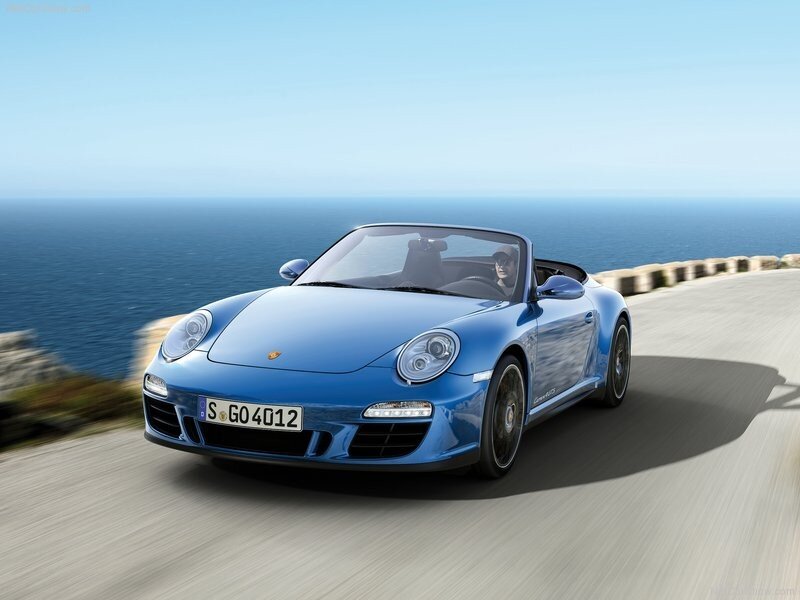 Blue Porsche convertible on coastal road