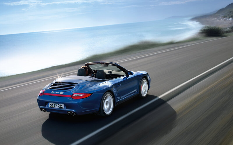 Blue Porsche convertible on coastal road