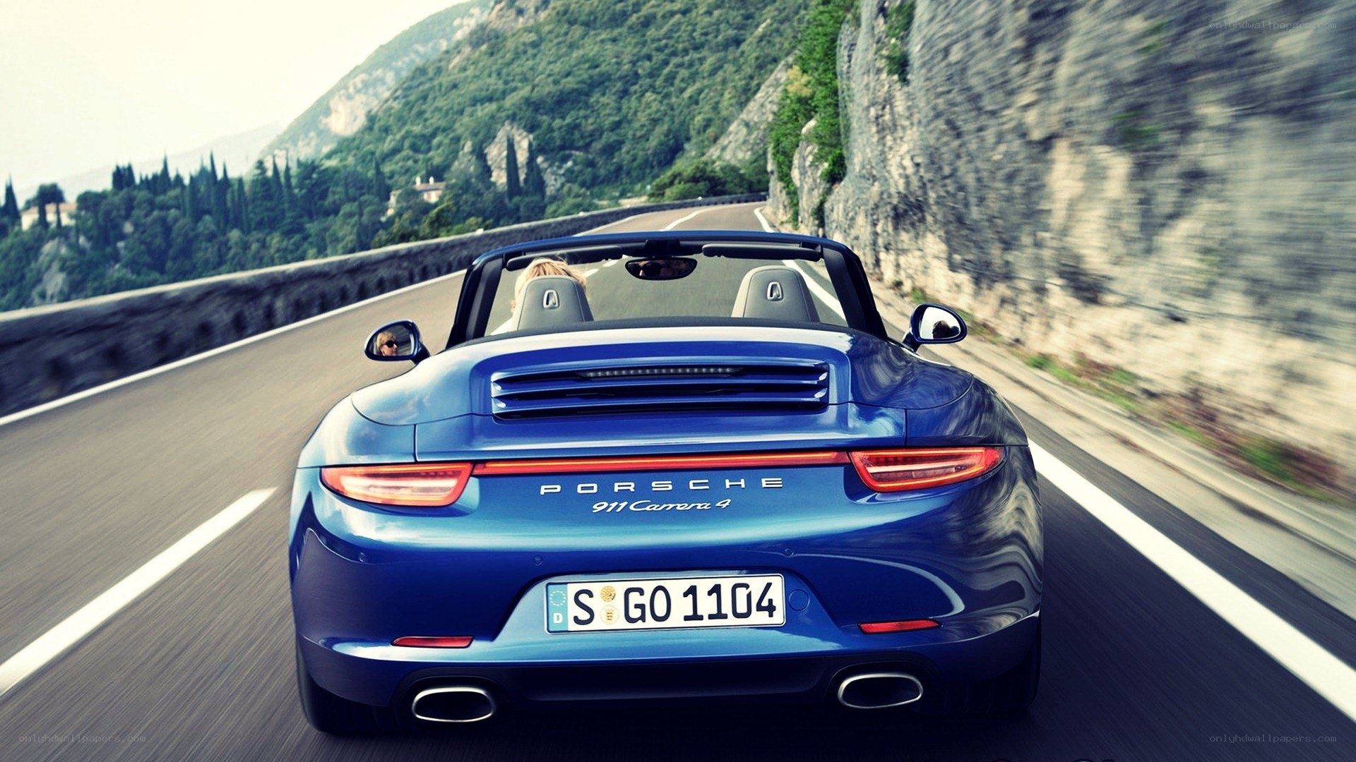 Blue Porsche convertible on mountain road
