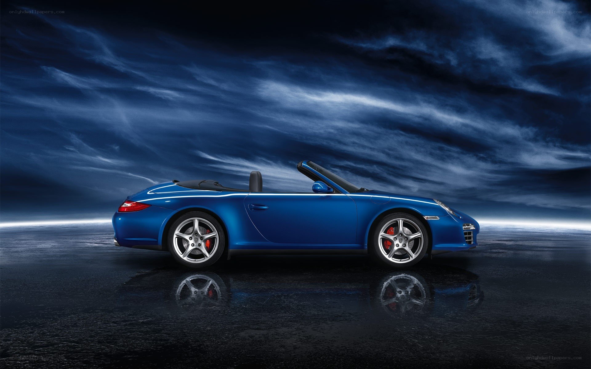 Blue Porsche convertible on wet surface
