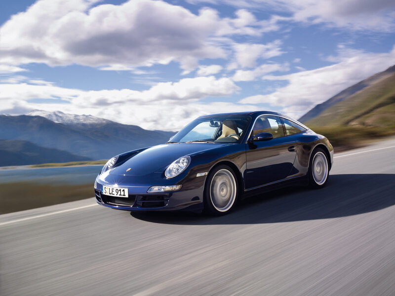 Blue Porsche driving on a scenic road