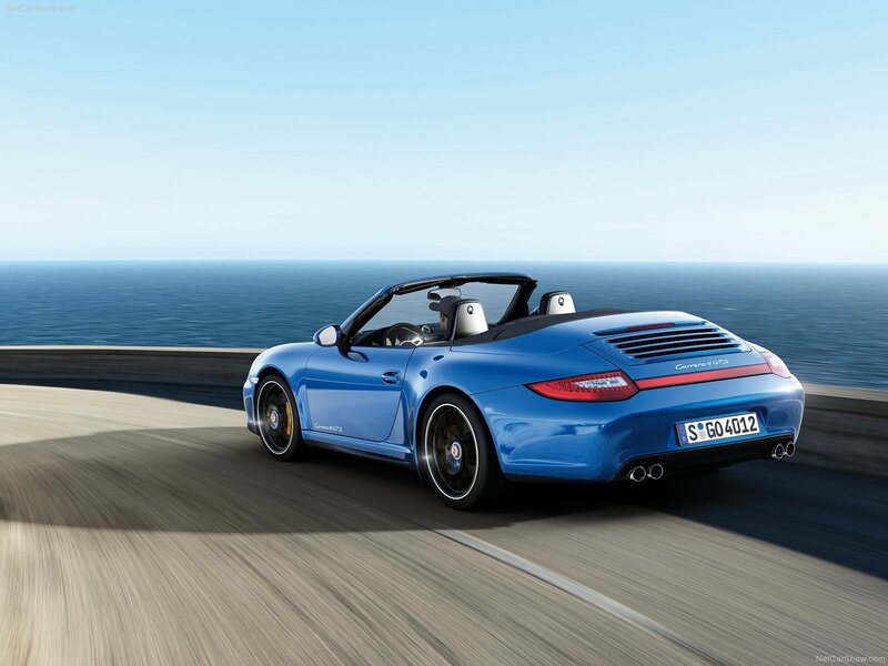 Blue Porsche driving on coastal road