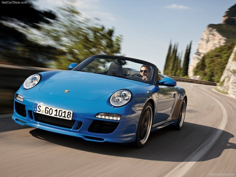 blue porsche driving on road