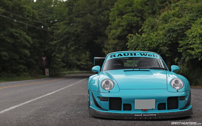 Blue Porsche on a forest road