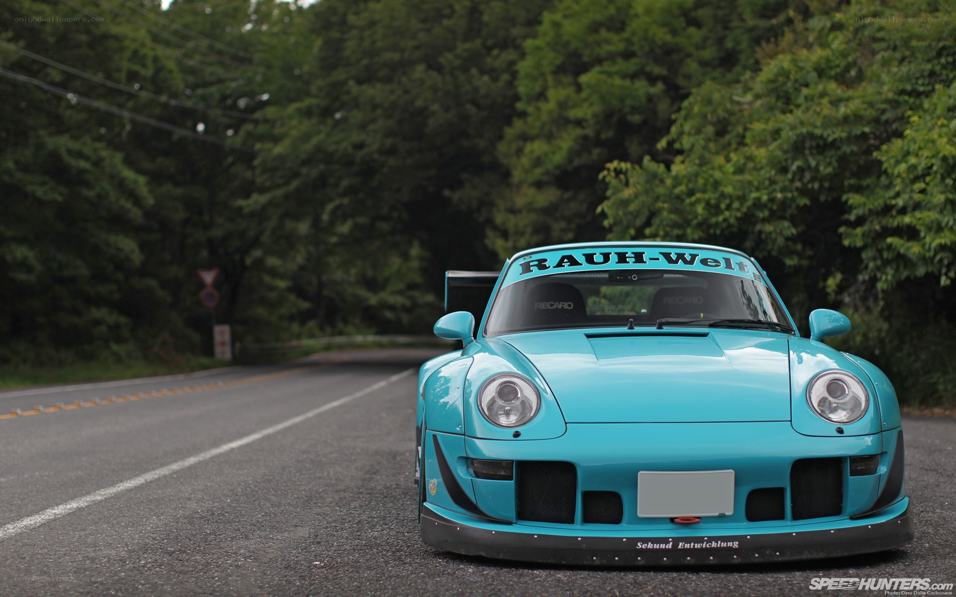 Blue Porsche on a forest road