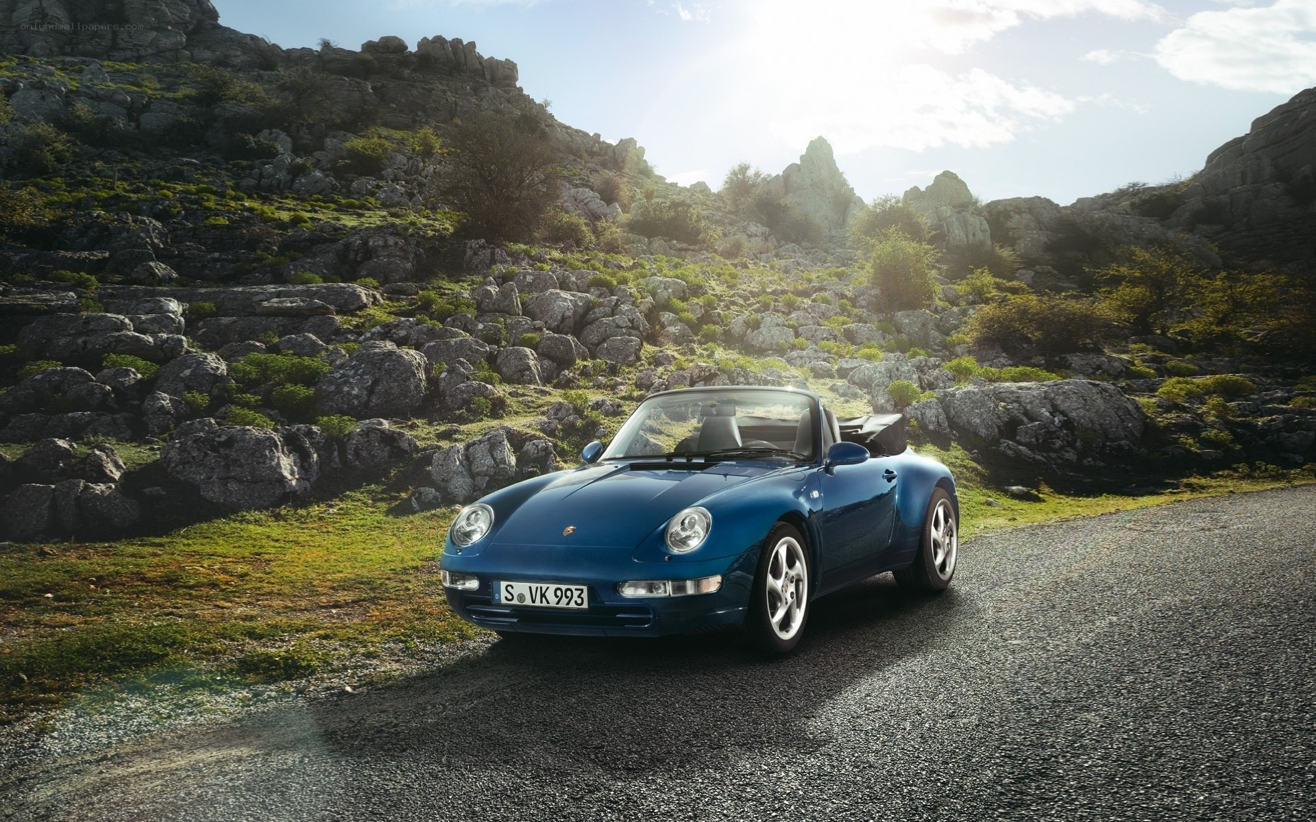 Blue Porsche on a mountain road