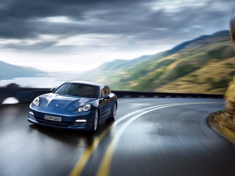Blue Porsche on a winding road