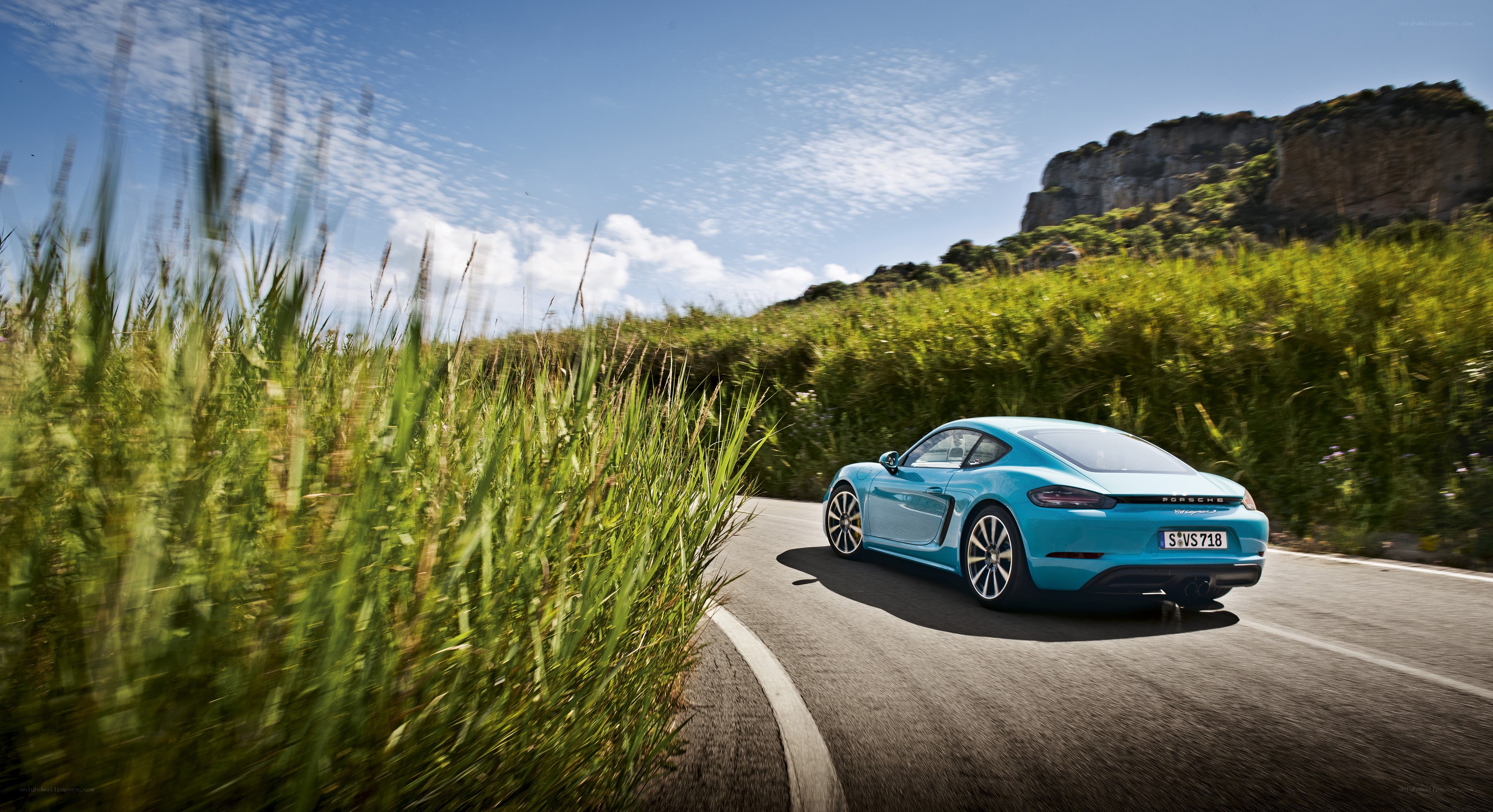 Blue Porsche on a winding road