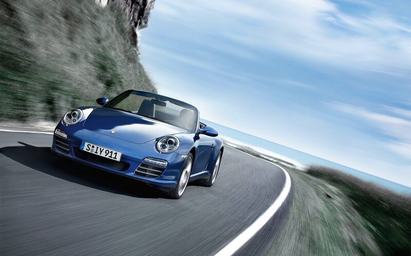 Blue Porsche on coastal road