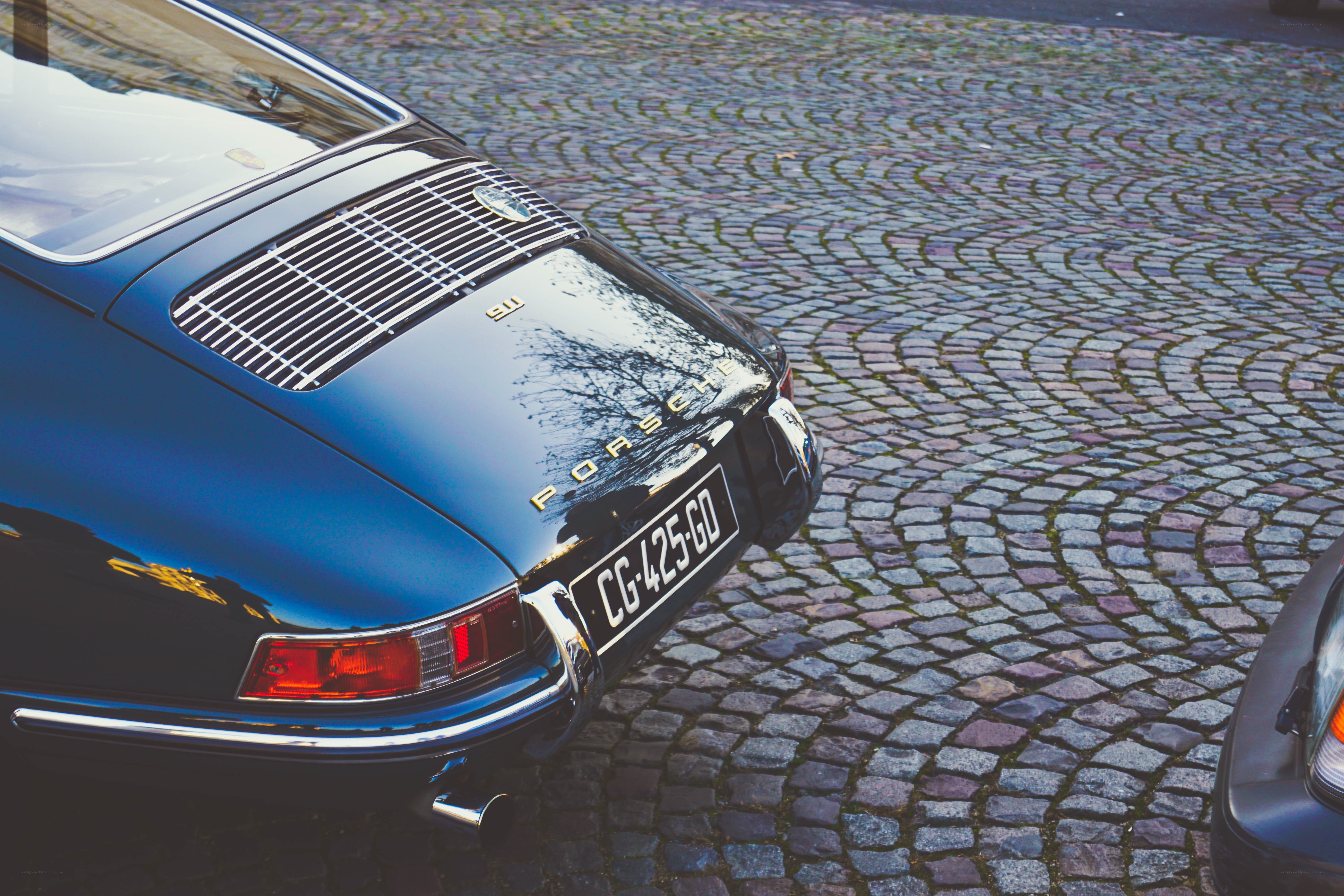 Blue Porsche on cobblestones